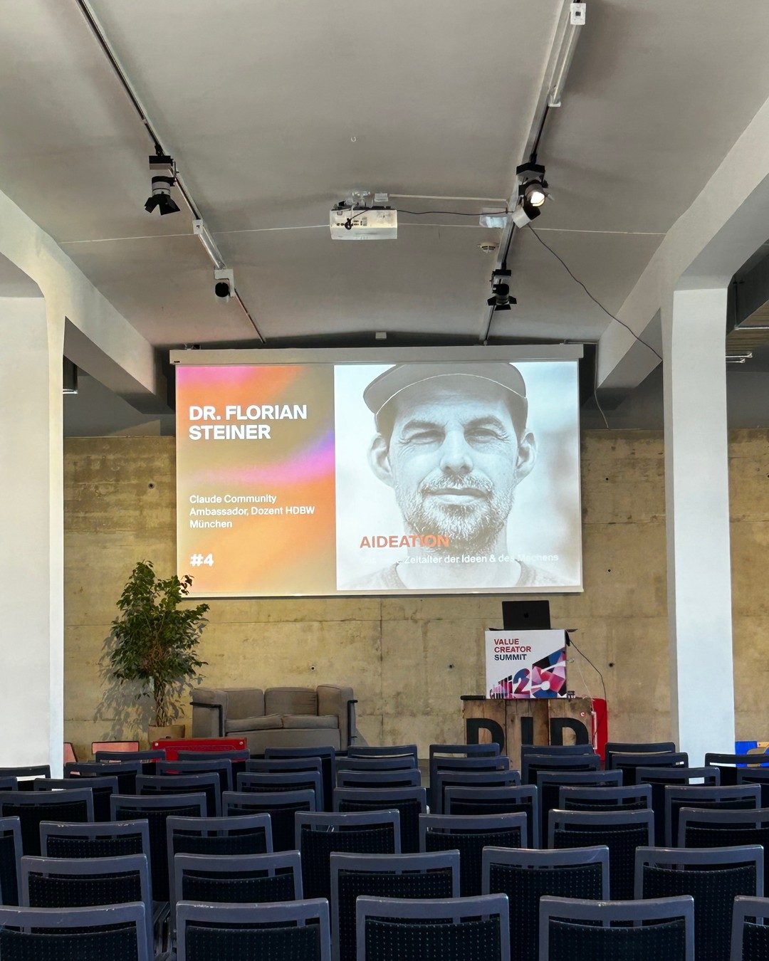 Der Saal im Südflügel in Kassel vor dem Vortrag, auf der Leinwand die Speaker-Folie von Dr. Florian Steiner